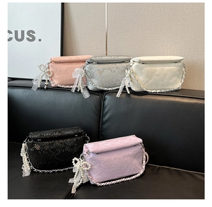 Detail view of stylish snakeskin pattern shoulder bags with lace bow charms and metal chains