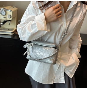 Detailed silver snakeskin texture bag with metallic chain and pearl bow charm