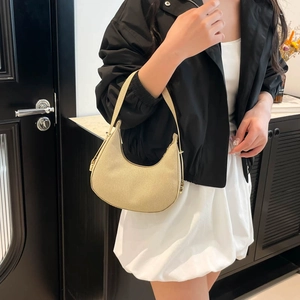 Minimalist beige half-moon shoulder bag with vertical stripe texture and gold hardware