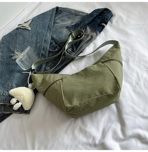 Detailed close-up of olive green dumpling bag with a cute white mushroom plush charm