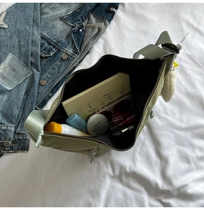 Top view of spacious olive green nylon crossbody bag with daily essentials inside