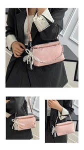 Detail of pink snake pattern crossbody bag with silver chain and pearl lace bow charm