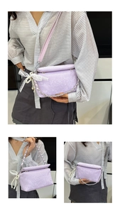 Detail of light purple snakeskin handbag with silver chain and lace pearl charm