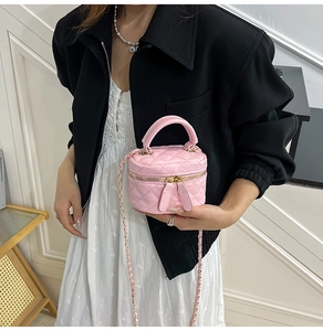 Detailansicht der rosafarbenen Mini-Handtasche mit Steppmuster und Kettenriemen