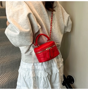 Detailansicht der roten gesteppten Mini-Tasche mit Lederkettenriemen und Metallzippern