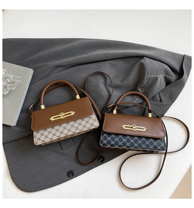 Macro shot of stylish contrast leather handbags with gold clasps and adjustable straps
