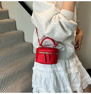 Nahaufnahme der roten gesteppten Mini-Umhängetasche mit goldener Kette am Model