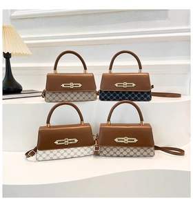 Detail of four bicolor crossbody box bags featuring golden locks on a white display