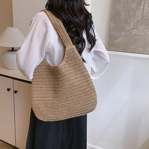 Large hand-woven shoulder tote bag in khaki knit, styled on model for a casual look