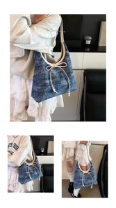 Detail der blauen Hobo-Tasche mit weißem Lederbesatz und Perlen-Schleifen-Verzierung