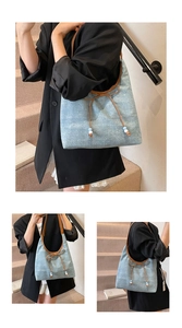 Detailansicht der Denim Hobo Bag mit brauner Lederschleife und Perlenanhängern