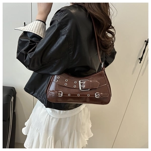 Detail of dark brown glossy shoulder bag with vintage silver buckle belts and eyelets