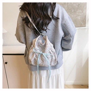 Sac à fleurs avec ruban à pois bleus porté en sac à dos dans un intérieur chaleureux