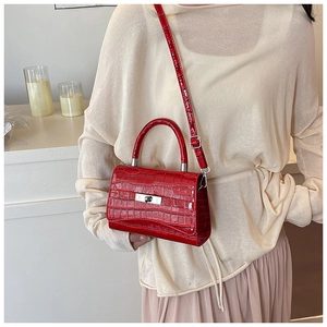 Red crocodile texture crossbody bag shown worn on shoulder with cream outfit