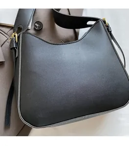 Detail of minimalist black matte half-moon bag with adjustable strap and gold hardware