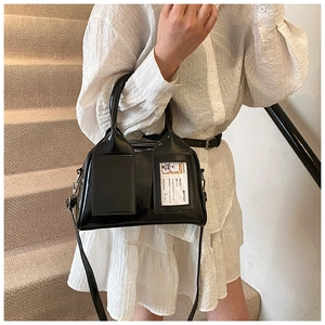 Détail d'un sac Boston en cuir verni noir avec cartes décoratives à motif d'ours BonBon