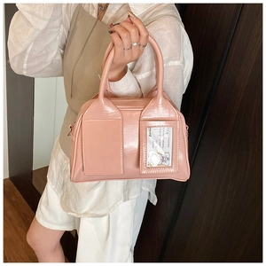 Détail du sac Boston en cuir verni rose avec fente pour carte ID et doubles poignées