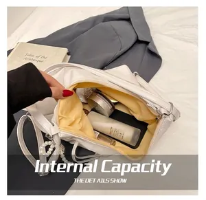 Detail view of large capacity white PU leather handbag interior with pearl chain accent
