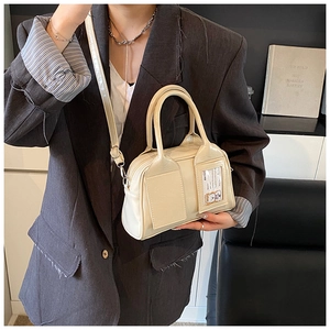 Détail du sac Boston blanc crème avec bandoulière réglable porté par un mannequin