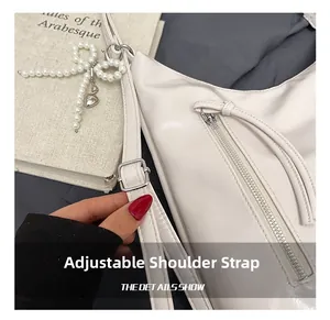 Detail showing adjustable shoulder strap and metal buckle on the white tote bag