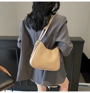 Detail view of the adjustable strap and tassel on this beige large capacity tote bag