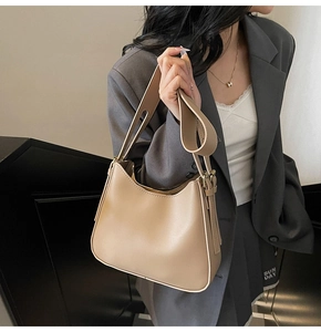 Detail view of beige matte leather tote bag with smooth curved bottom and wide strap