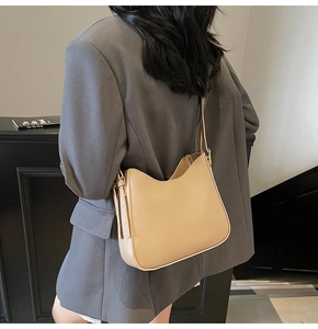 Detail of light khaki leather tote bag with slim shoulder strap and metal buckle adjustment