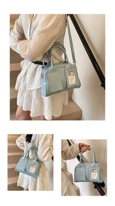 Sac Boston bleu clair en similicuir porté en bandoulière, à l'épaule et à la main