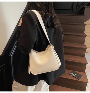Chic beige hobo tote bag detail with long strap on office commuter outfit