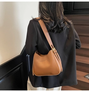 Detail showing adjustable strap and golden hardware on the brown leather tote bag