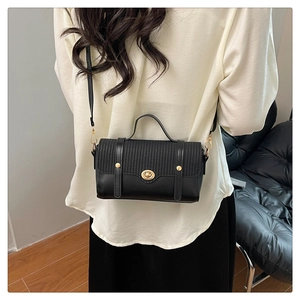 Rear view of model wearing a black leather and woven mini bag with golden lock