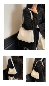 Detail of soft off-white faux leather hobo bag featuring stylish tassel charms and wide strap