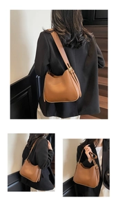 Detail of caramel brown matte leather tote bag with adjustable shoulder strap and metal buckle