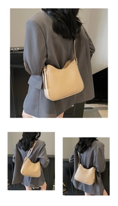 Detail view of beige soft leather hobo bag with side buckle and tassel accents