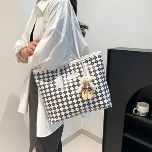 Classic black and white checkered tote bag with plush bear charm and thin shoulder straps