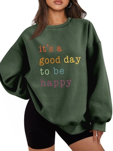 Detail of colorful 'it's a good day' print on dark green plush fleece sweatshirt