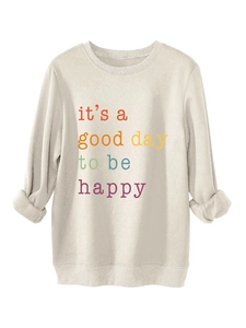Detail of the colorful rainbow text print on the beige long sleeve crewneck sweatshirt