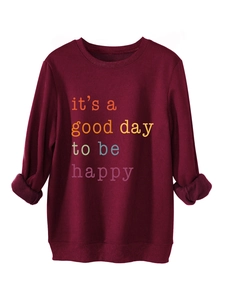 Detail of burgundy plush sweatshirt featuring it's a good day to be happy slogan print