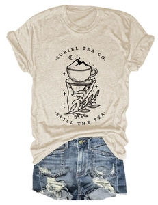 Détail à plat d'un t-shirt beige Suriel Tea Co. avec un ensemble de shorts en jean