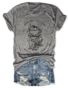Détail du t-shirt graphique Suriel Tea Co. et du short en jean vieilli pour femmes