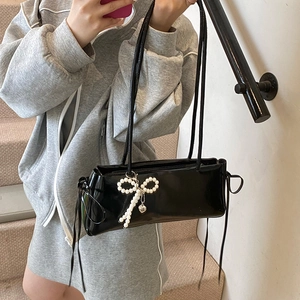 Minimalistische zwarte lakleren schoudertas met parelstrikn en hartvormige hanger