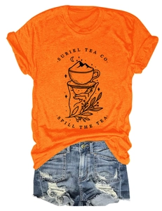 Détail du t-shirt orange Suriel Tea Co avec imprimé graphique et short en jean bleu
