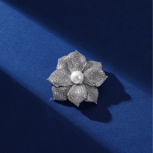 Broche fleur étincelante avec perle d'eau douce et zircons sur fond bleu foncé
