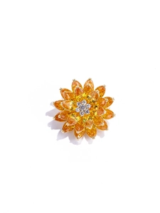 Détail d'une broche lotus à trois couches avec cristaux jaunes et centre en diamants