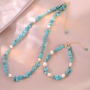 Bohemian turquoise stone and freshwater pearl necklace set on pink silk background