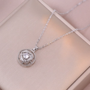 Gros plan d'un collier pendentif fleur rotatif en argent avec cristaux brillants