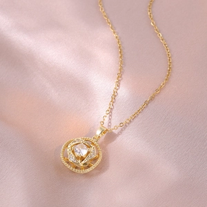 Détail d'un collier fleur rotative dorée avec zircon sur un tissu en satin rose doux