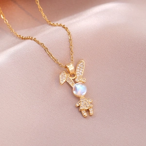 Golden rabbit pendant necklace with sparkling zircons and rainbow moonstone on pink silk