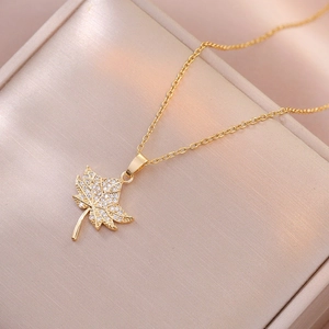 Elegant gold maple leaf pendant necklace with shimmering zircon crystals in a gift box
