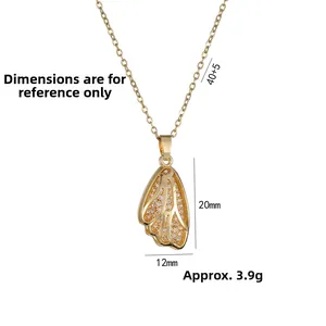 Macro detail of gold double-layer wing pendant with dimensions and zircon inlay